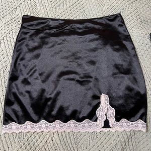 Black satin mini skirt with white lace trim, small slit. Great condition Size L